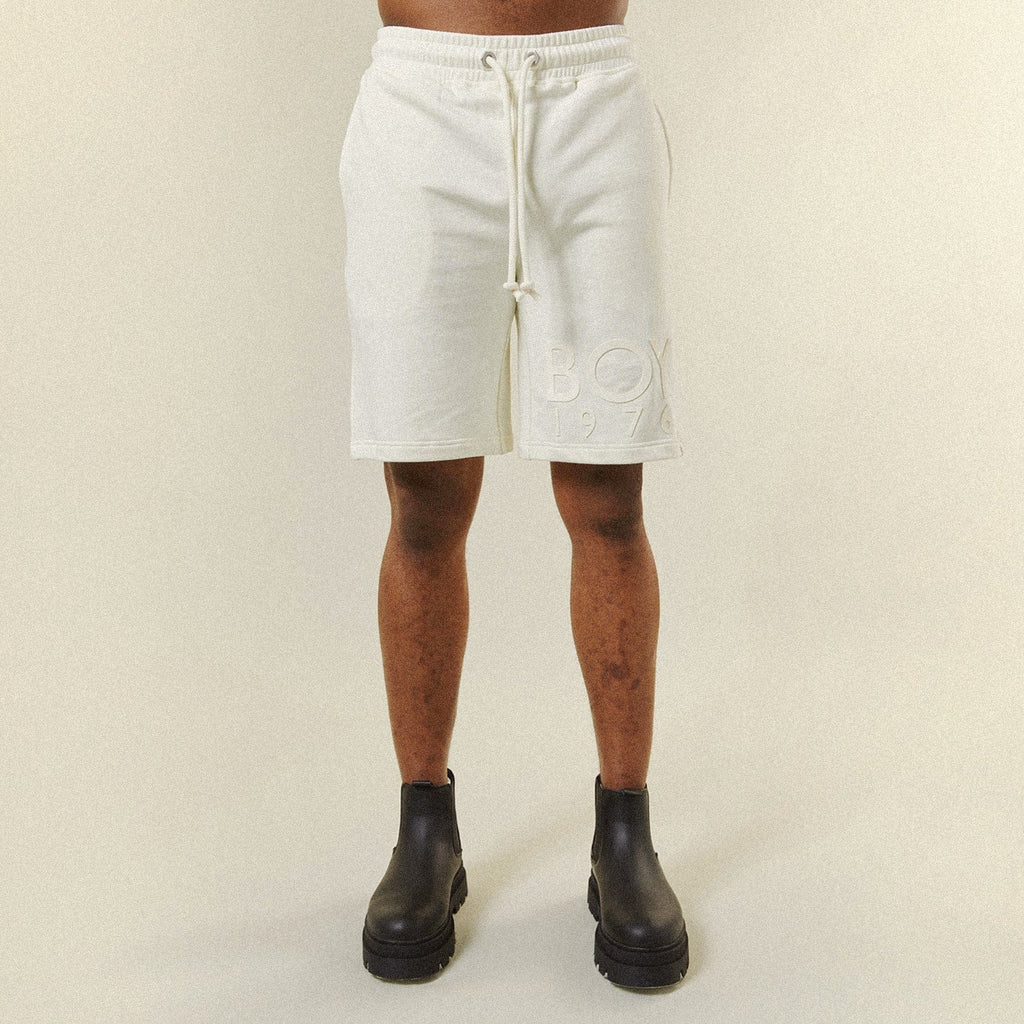 Model wearing BOY London shorts on plain background