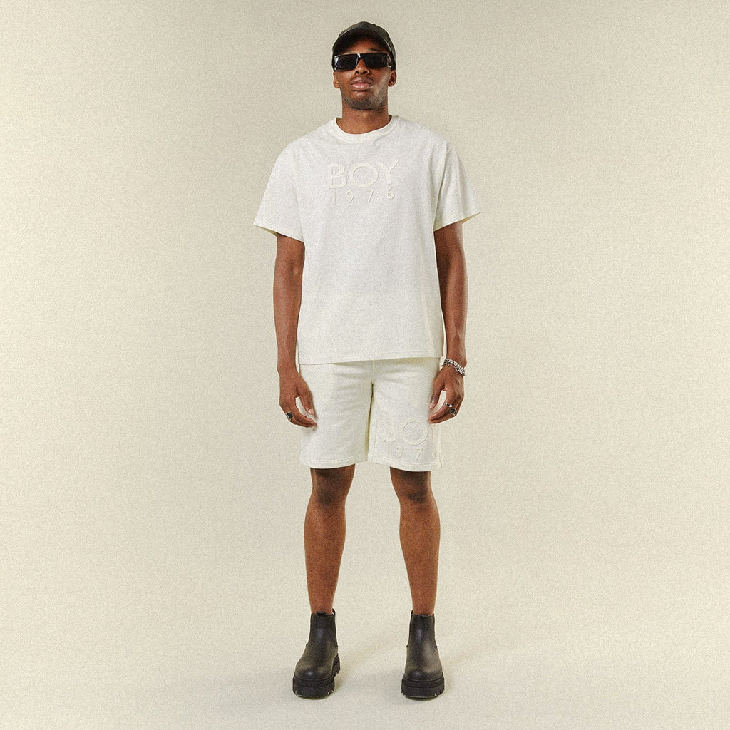 Model wearing BOY London shorts on plain background