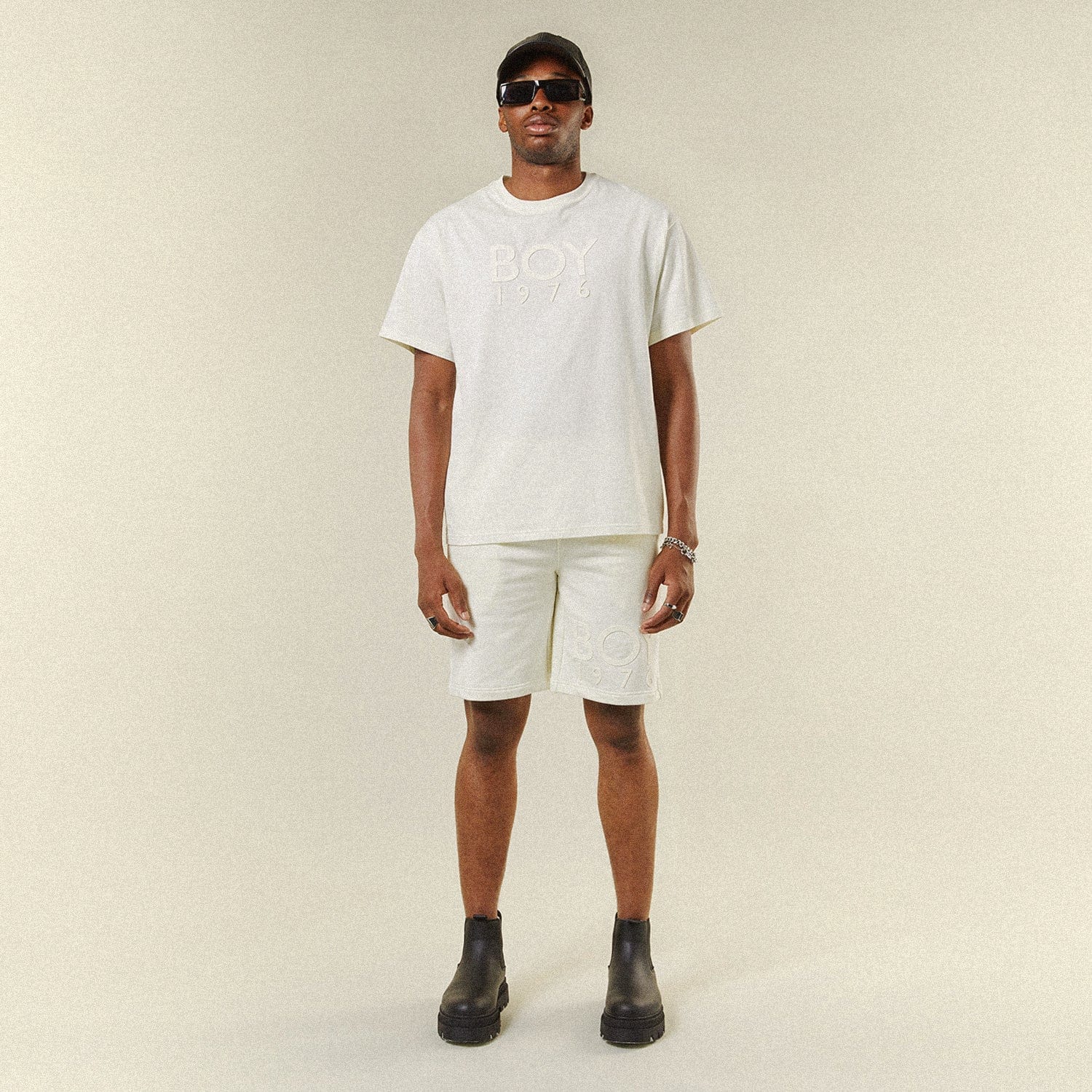Model wearing BOY London shorts on plain background