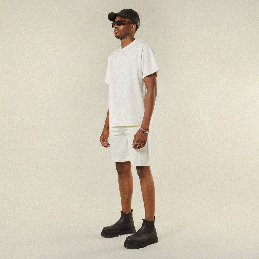 Model wearing BOY London shorts on plain background