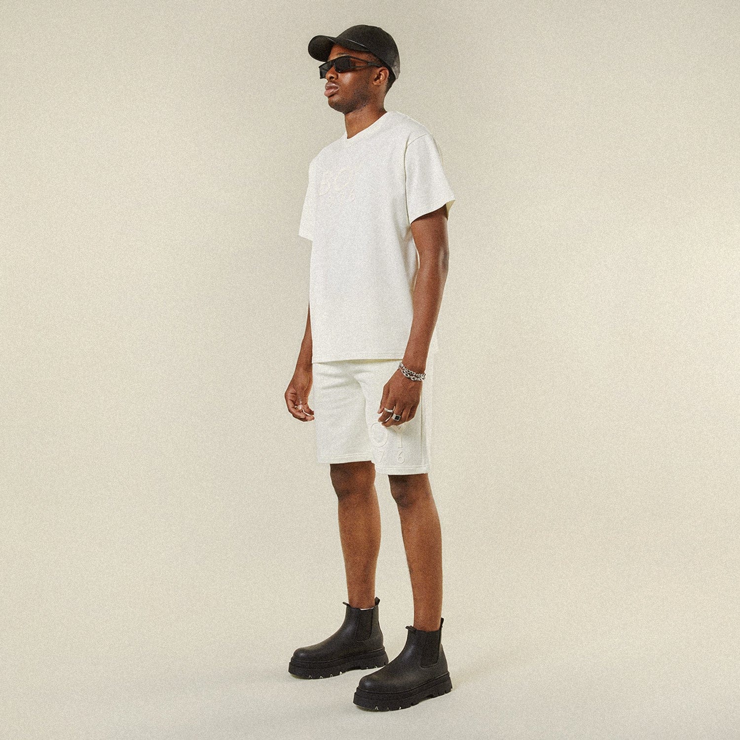 Model wearing BOY London shorts on plain background
