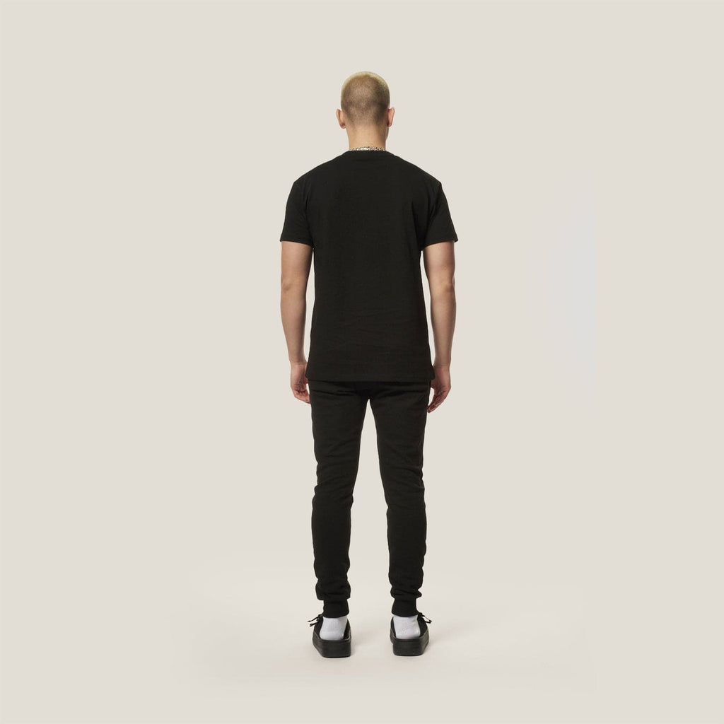 Model wearing black boy london joggers on plain background