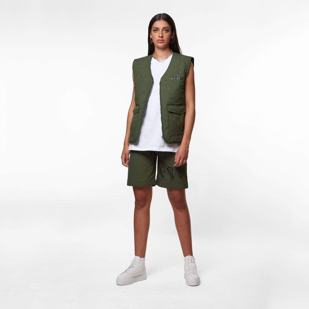 Female model wearing Boy London green gilet on white background