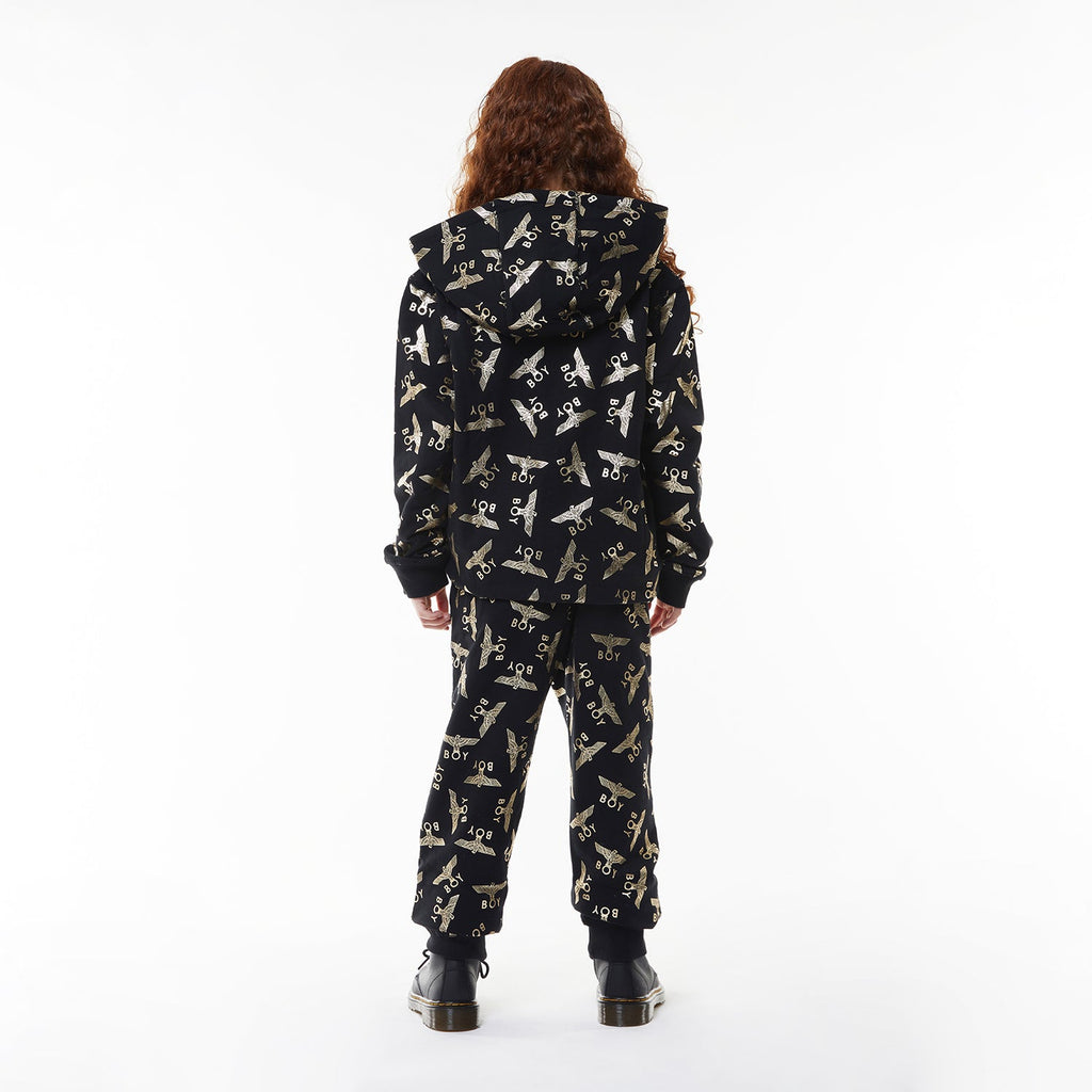 Model wearing Black Boy London pants with yellow airplane pattern on a white background