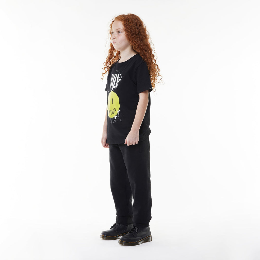 Model wearing Black BOY London t-shirt with yellow smiley face and 'BOY London' text on a white background