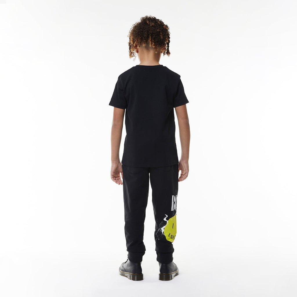 Model wearing Black BOY London t-shirt with yellow smiley face and 'BOY London' text on a white background