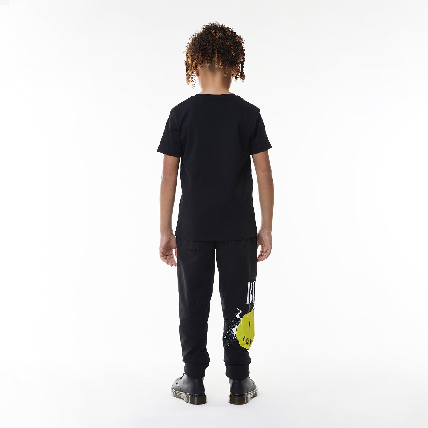 Model wearing Black BOY London t-shirt with yellow smiley face and 'BOY London' text on a white background