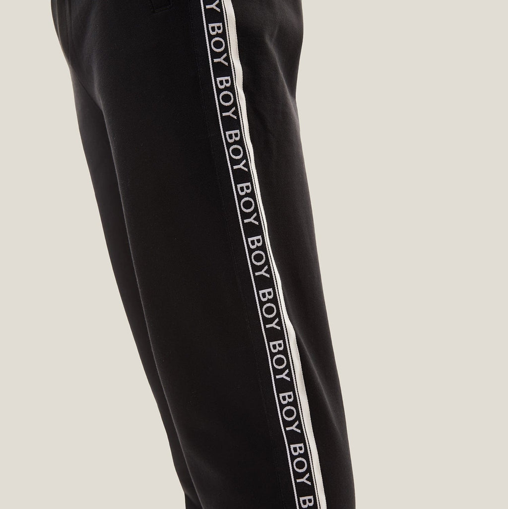 model wearing boy london joggers on plain background 