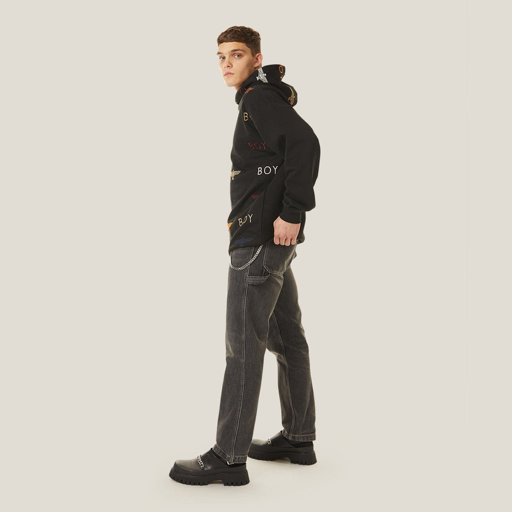 Model wearing Black hoodie with 'BOY' London and logo pattern on a white background