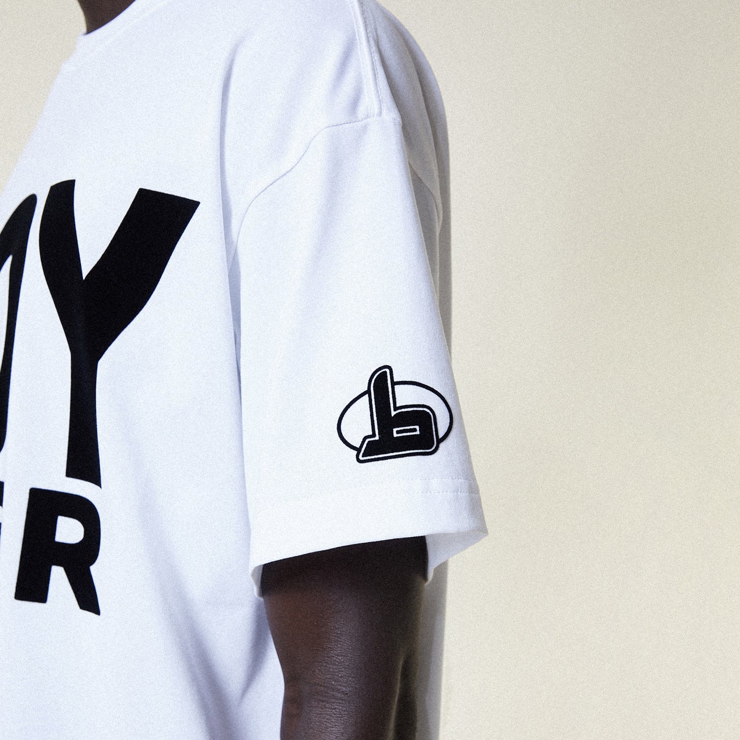 Person wearing a BOY LONDON white t-shirt with 'BOY RACER' text, black shorts, and black boots on a plain background
