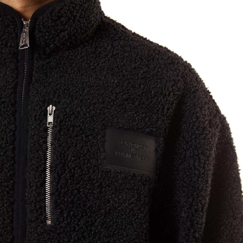 Model wearing Black BOY London fleece jacket with a brand logo on a white background