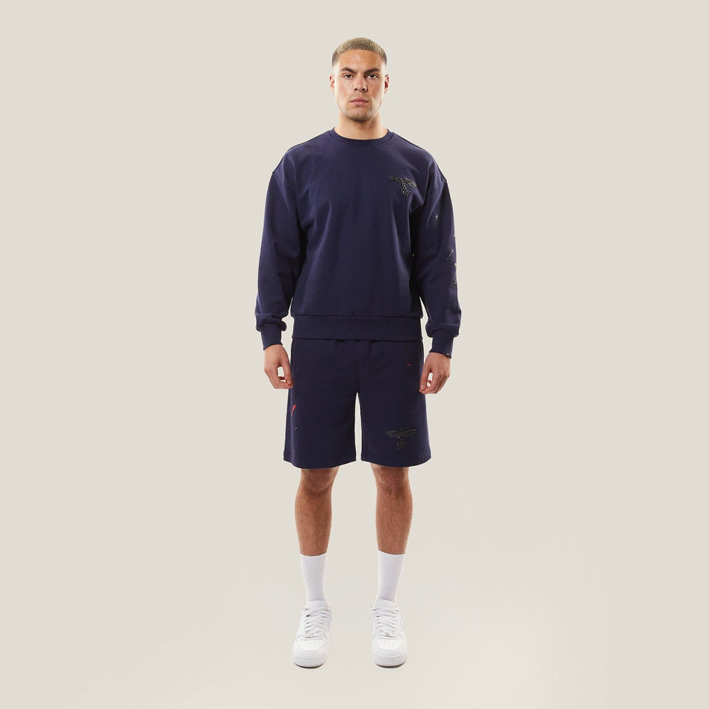 Model wearing BOY London Navy blue shorts on a white background