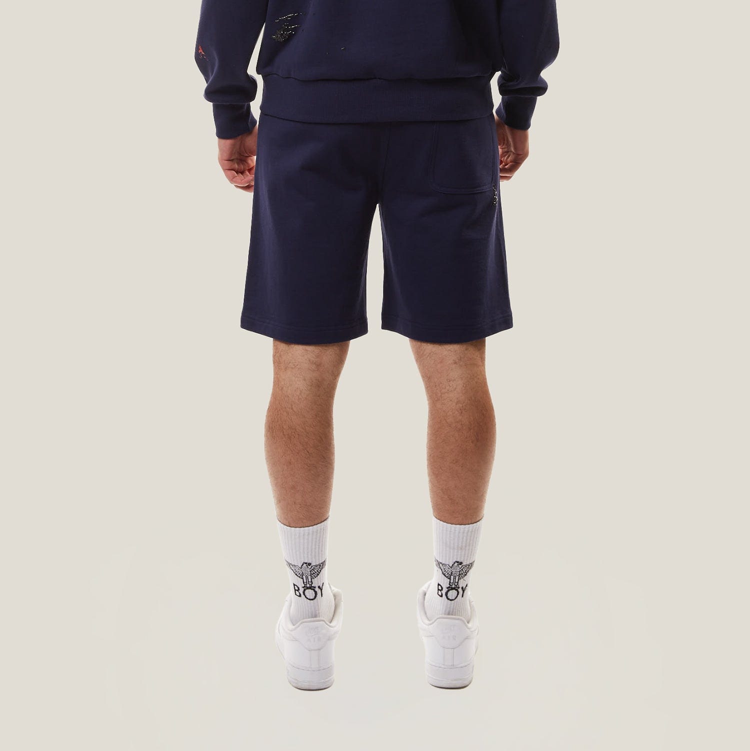 Model wearing BOY London Navy blue shorts on a white background