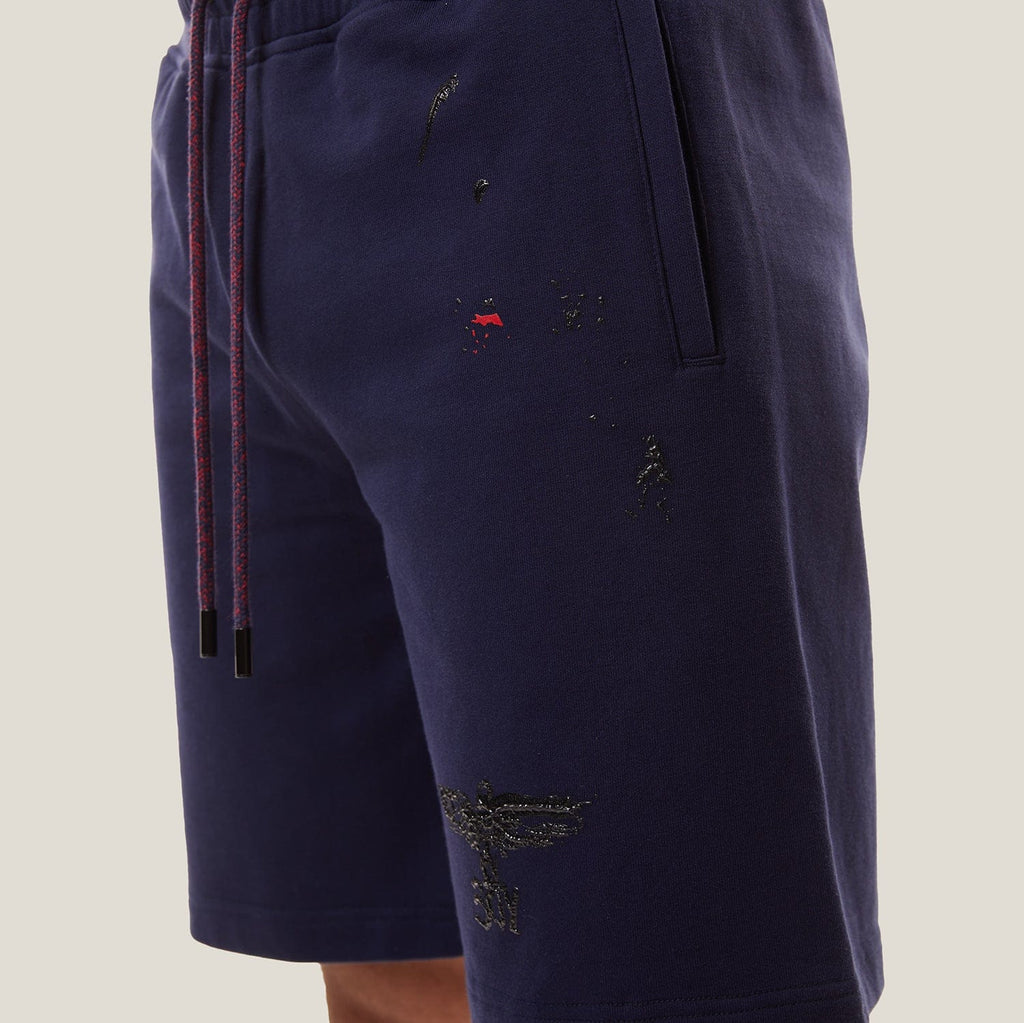 Model wearing BOY London Navy blue shorts on a white background
