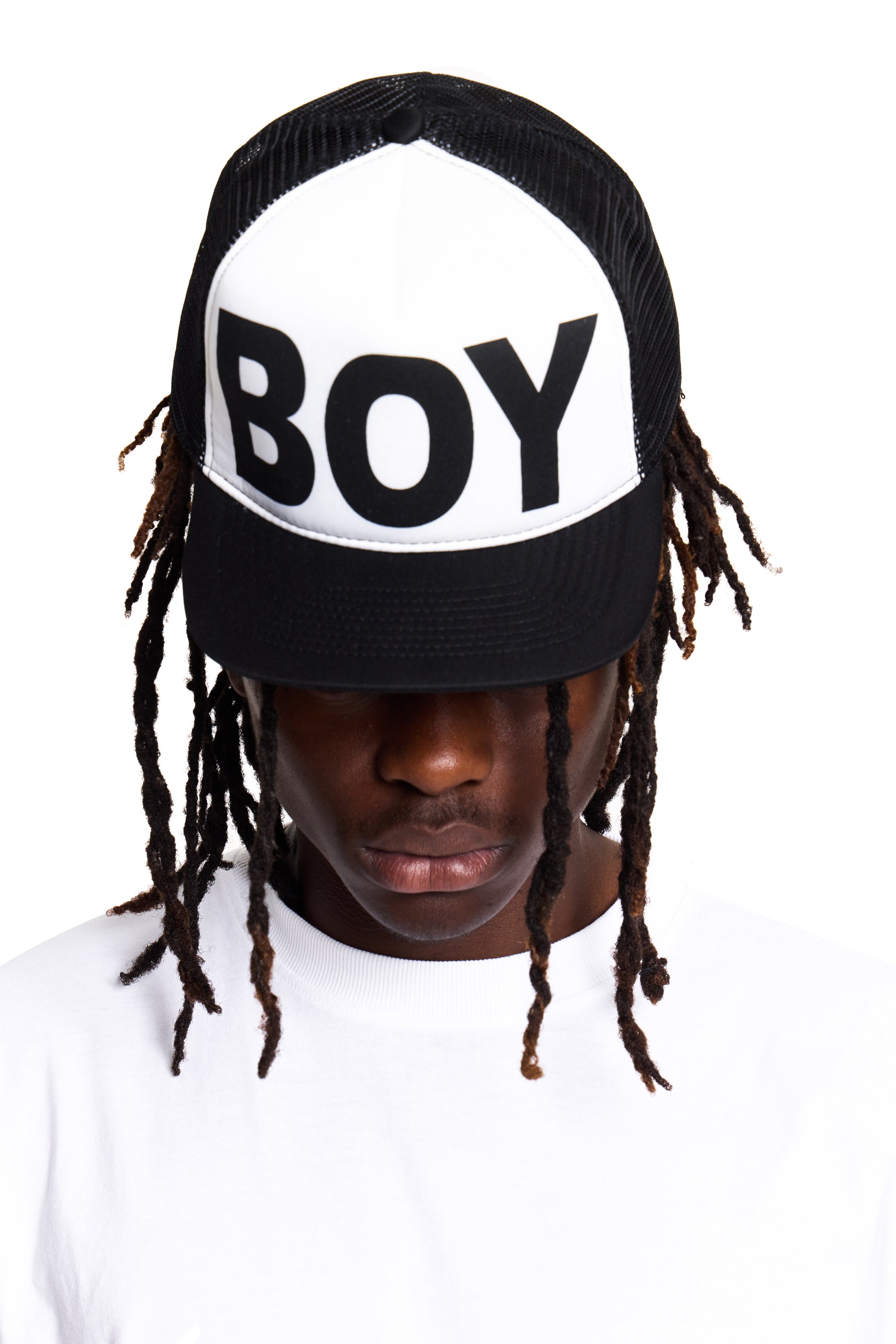 Person wearing a cap with 'BOY' London text on a white background