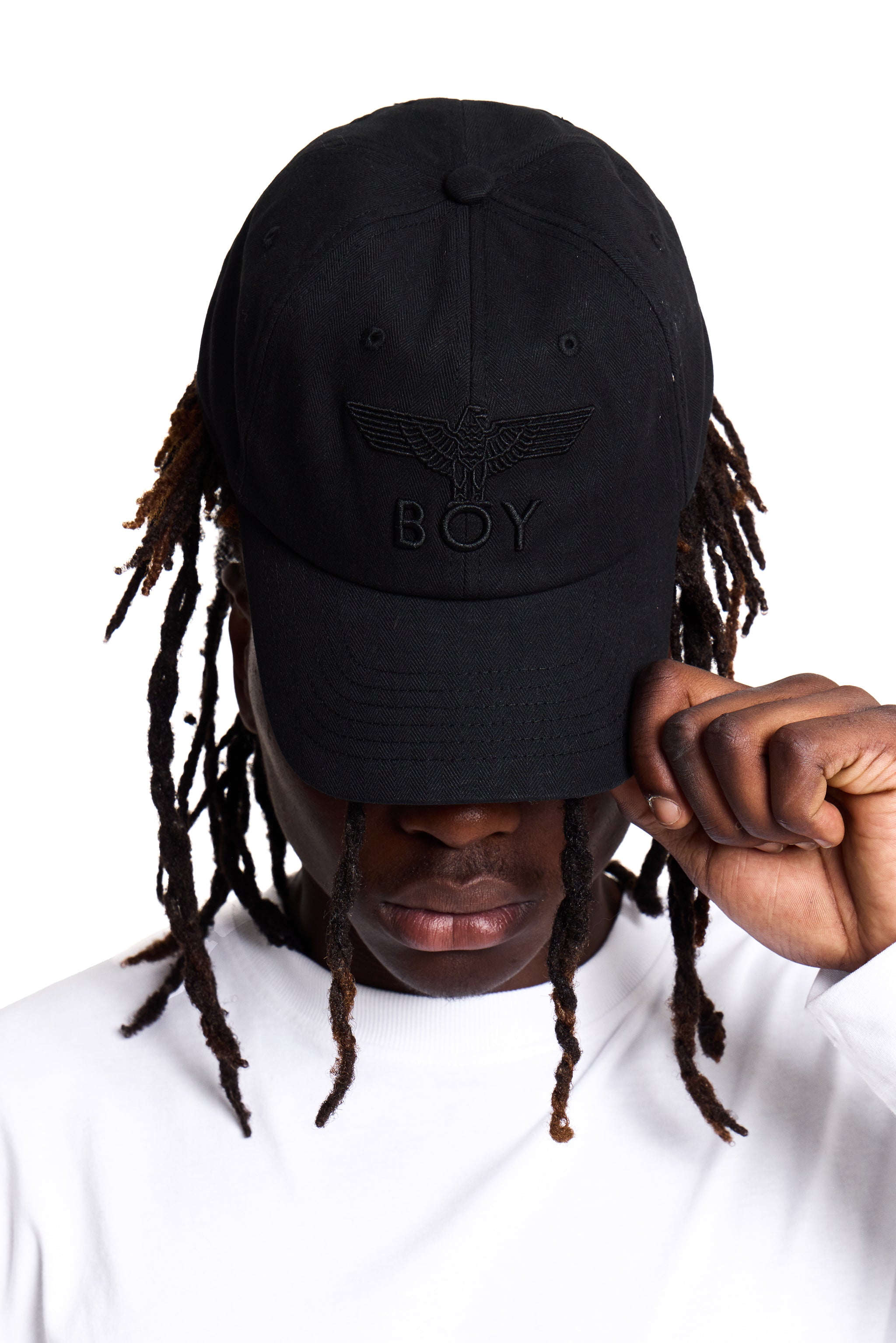 Person wearing a black cap with 'BOY' London logo on a white background