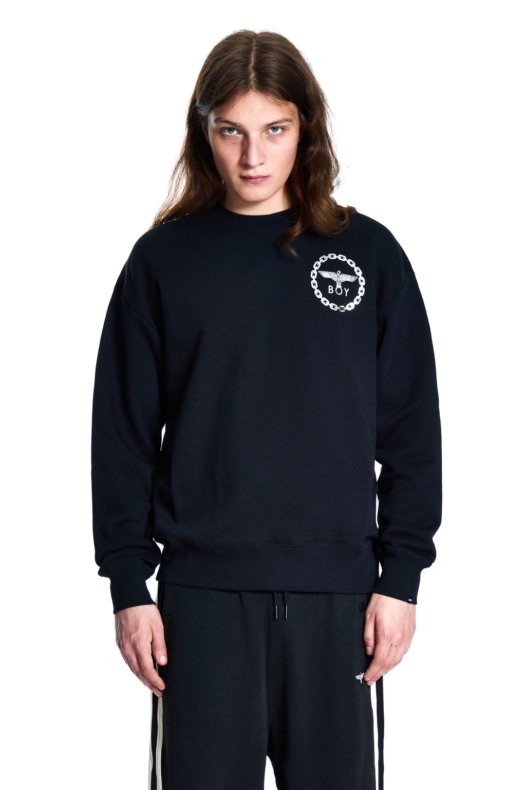 Person wearing a black Boy London sweatshirt with a logo on a white background