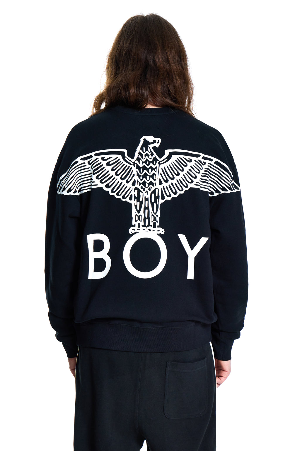Person wearing a black Boy London sweatshirt with an eagle design and 'BOY' text on the back, on a white background.