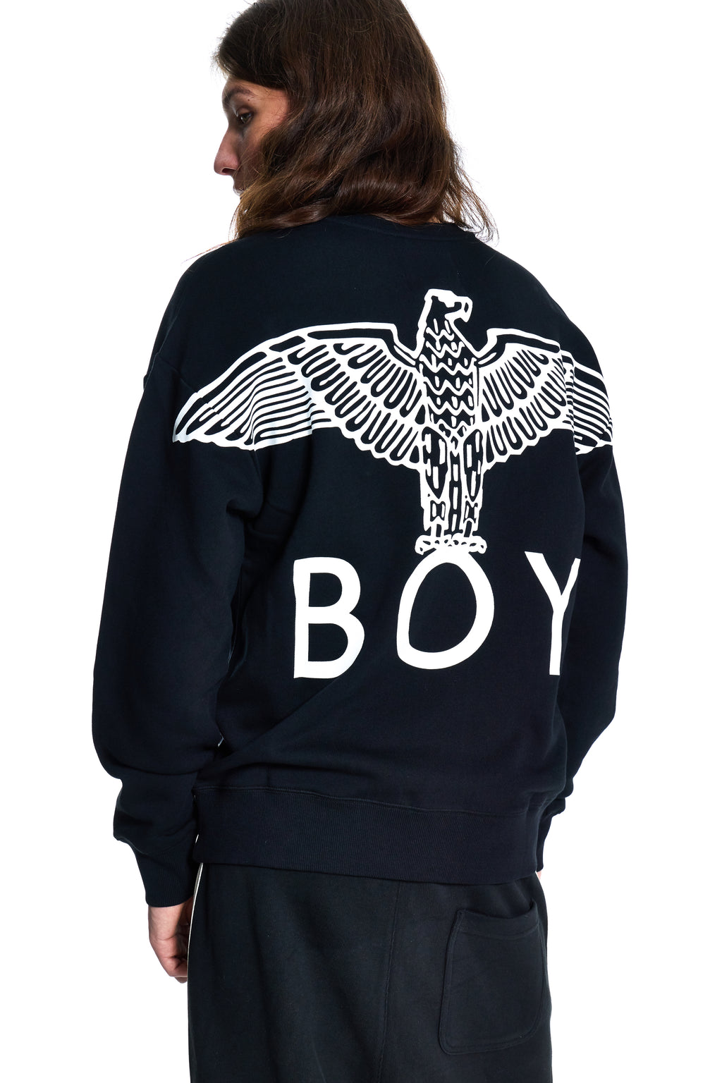 Person wearing a black sweatshirt with a white eagle design and 'BOY' text on the back.
