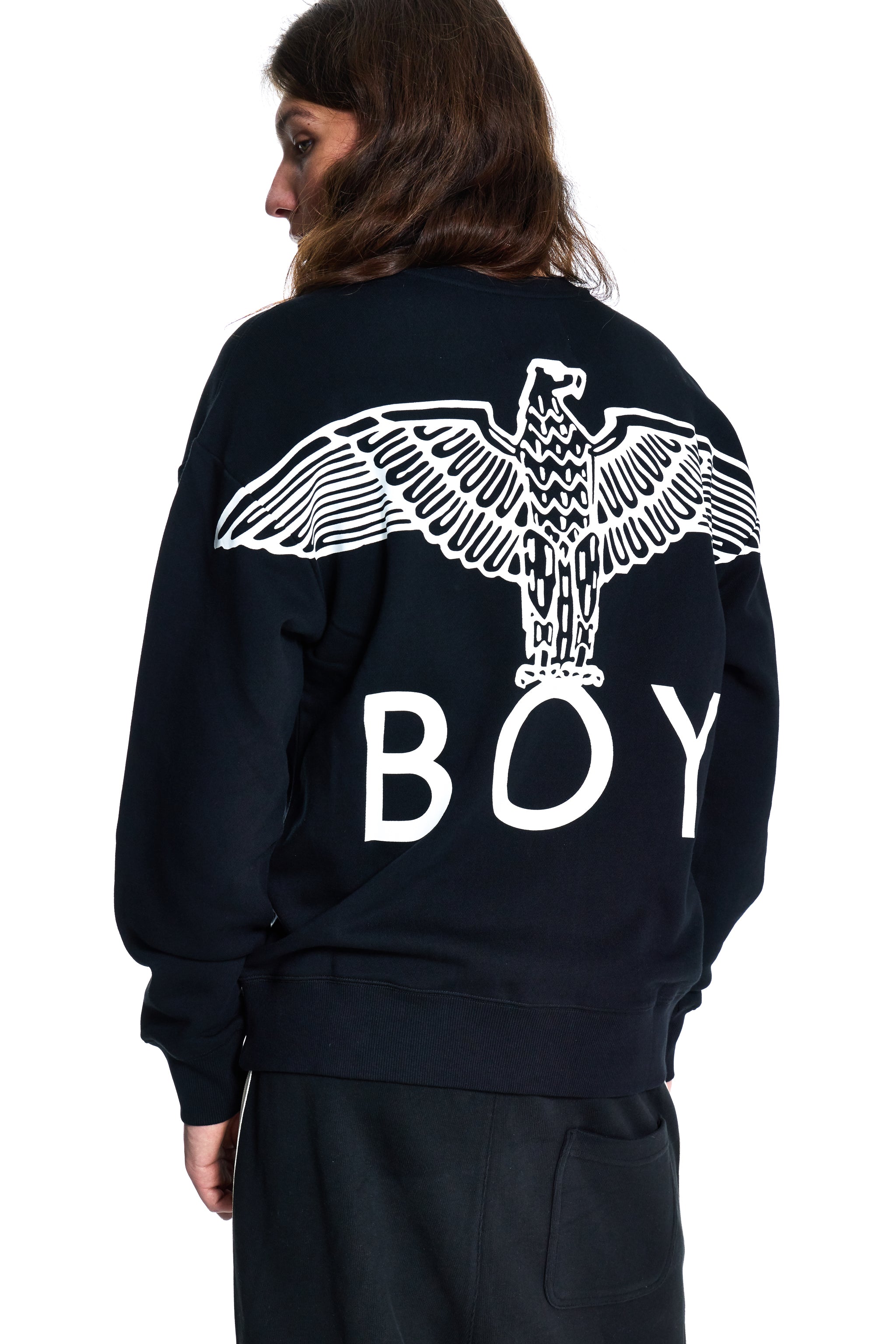 Person wearing a black sweatshirt with a white eagle design and 'BOY' text on the back.
