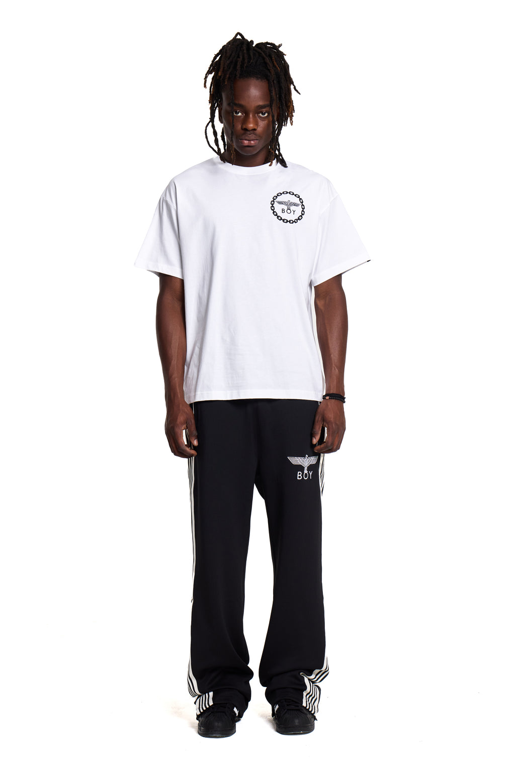 Model wearing a white BOY London t-shirt and black pants with visible branding on a white background