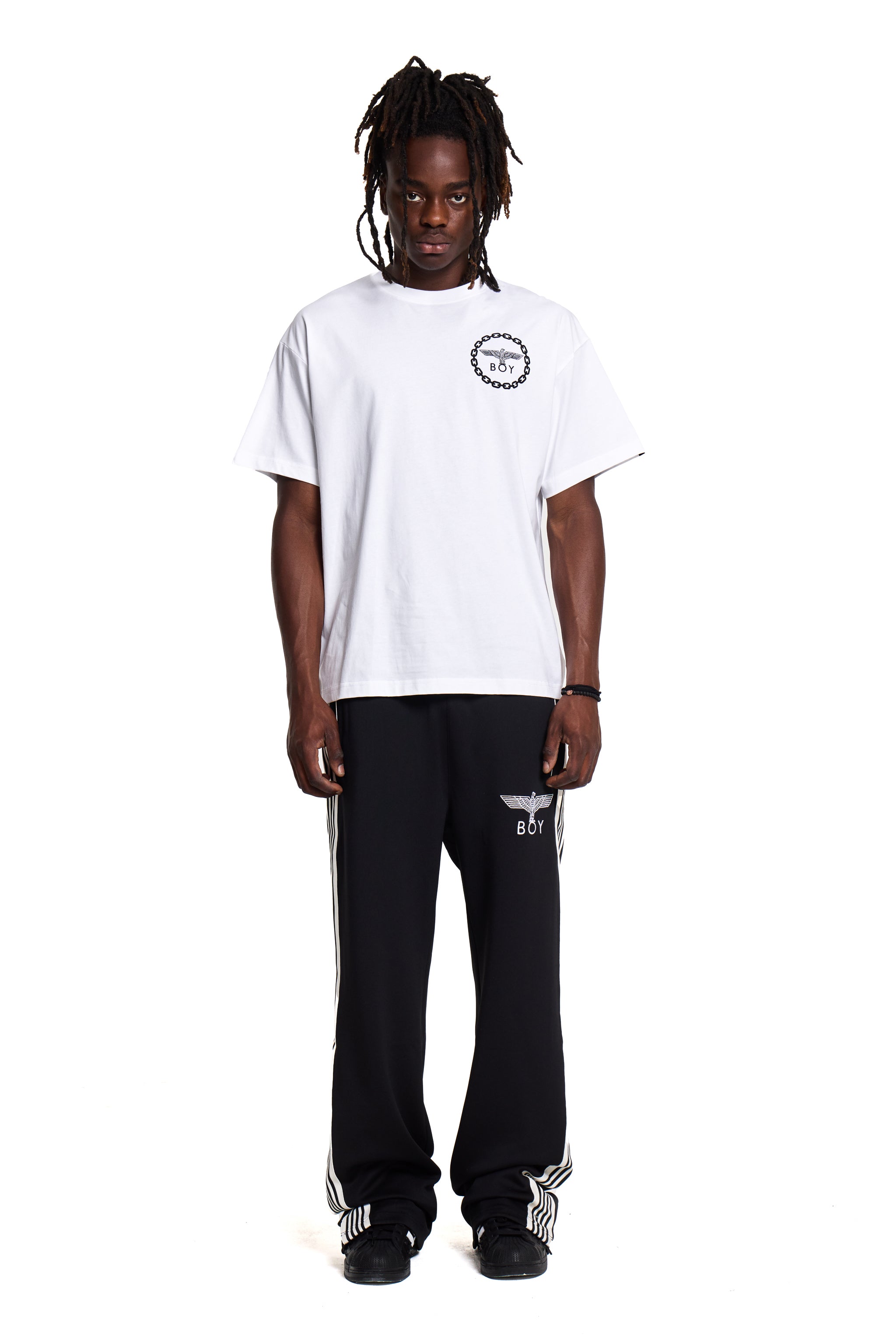 Model wearing a white BOY London t-shirt and black pants with visible branding on a white background