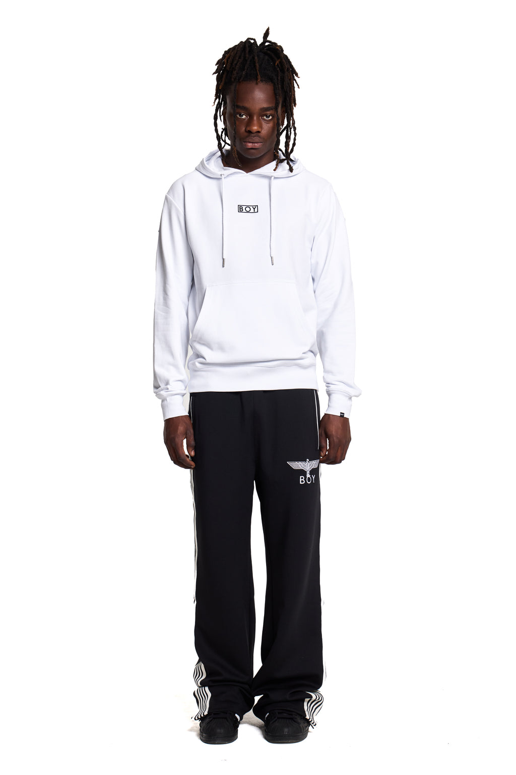 Model wearing a white BOY London hoodie and black pants with a logo on a white background