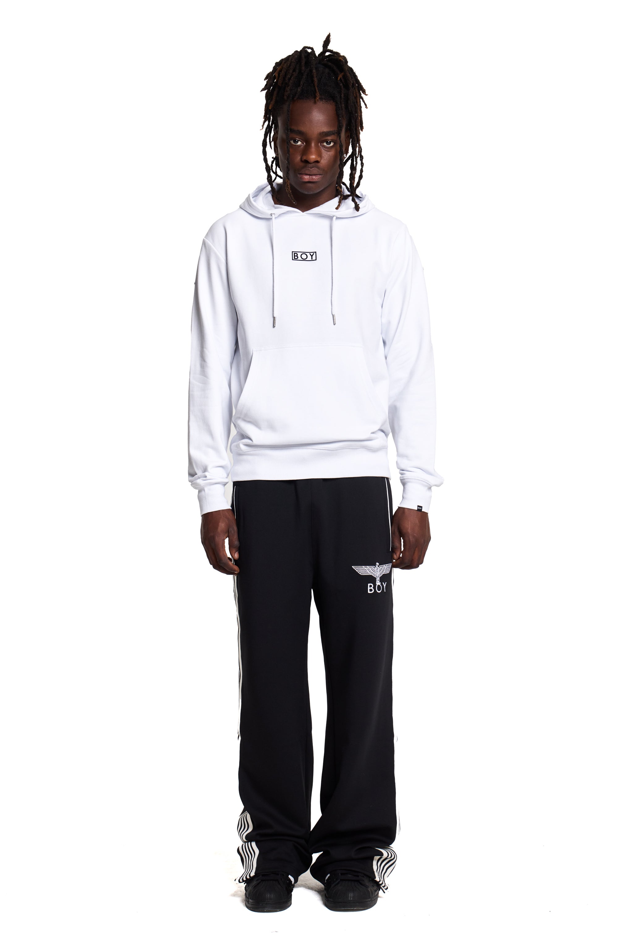Model wearing a white BOY London hoodie and black pants with a logo on a white background