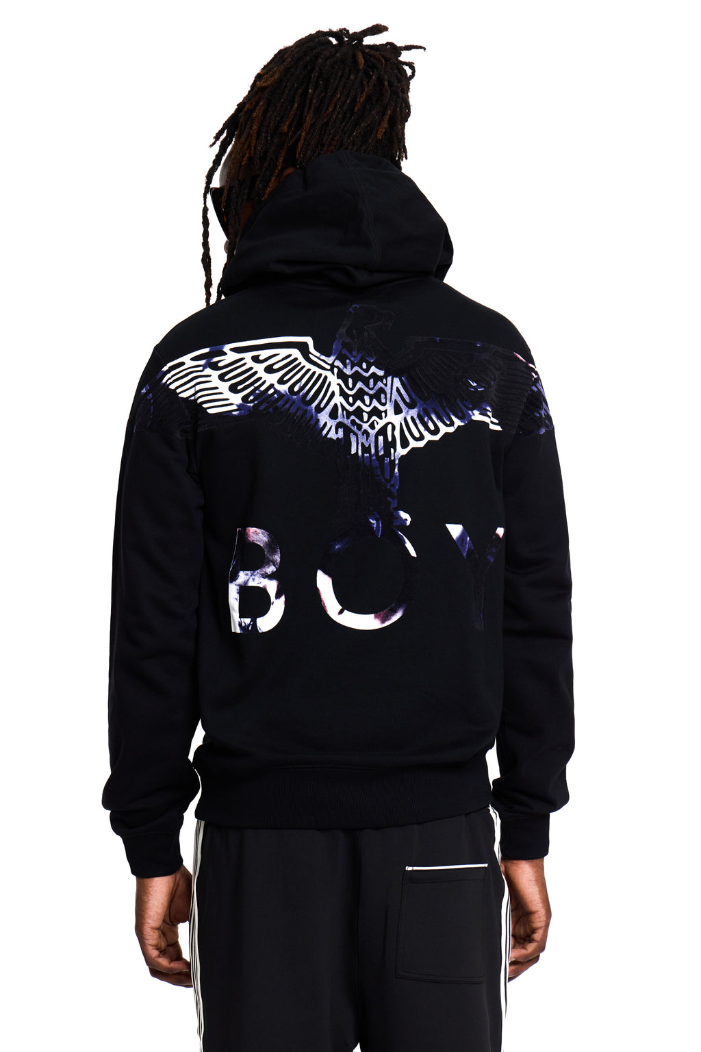Model wearing a black BOY London hoodie with a logo on the back against a white background