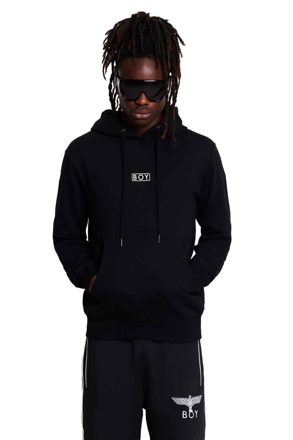 Model wearing a black BOY London hoodie and pants with brand logos on a white background