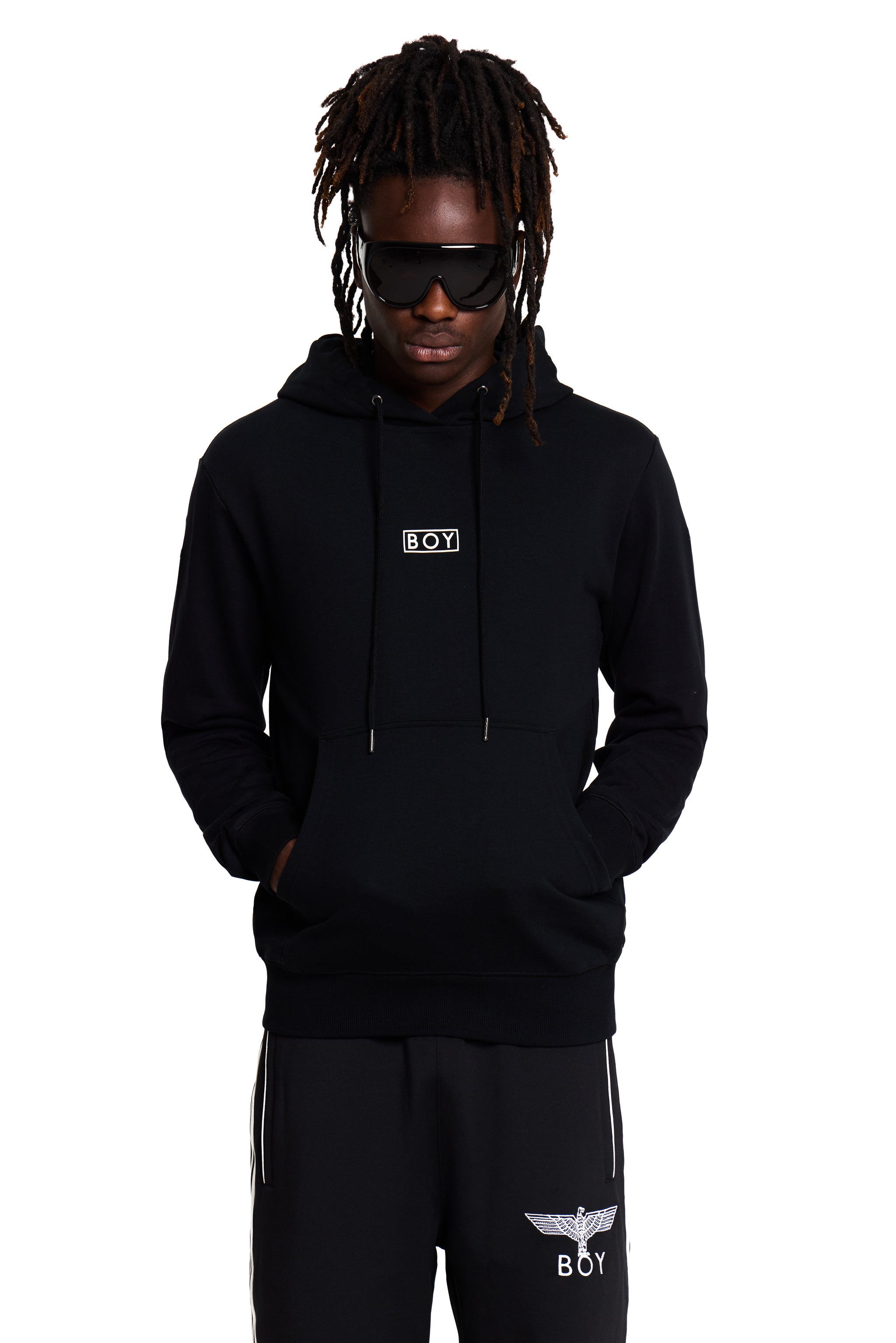Model wearing a black BOY London hoodie and pants with brand logos on a white background