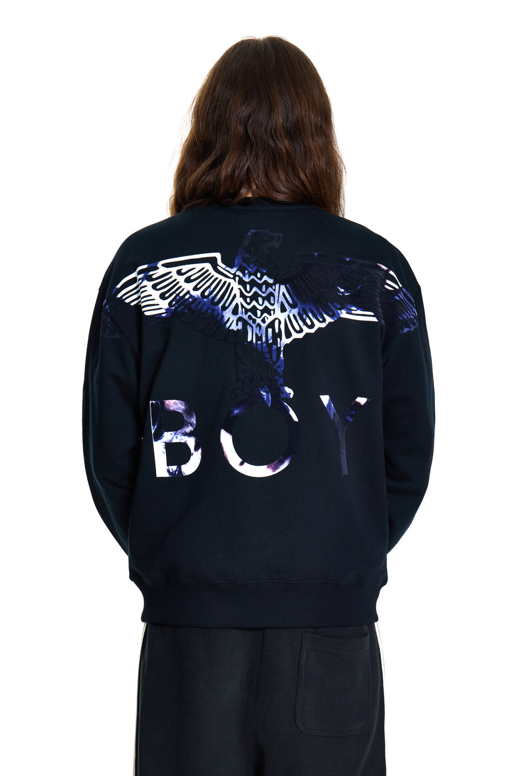 Person wearing a dark blue BOY London hoodie with a reflective design on the back, standing against a white background.