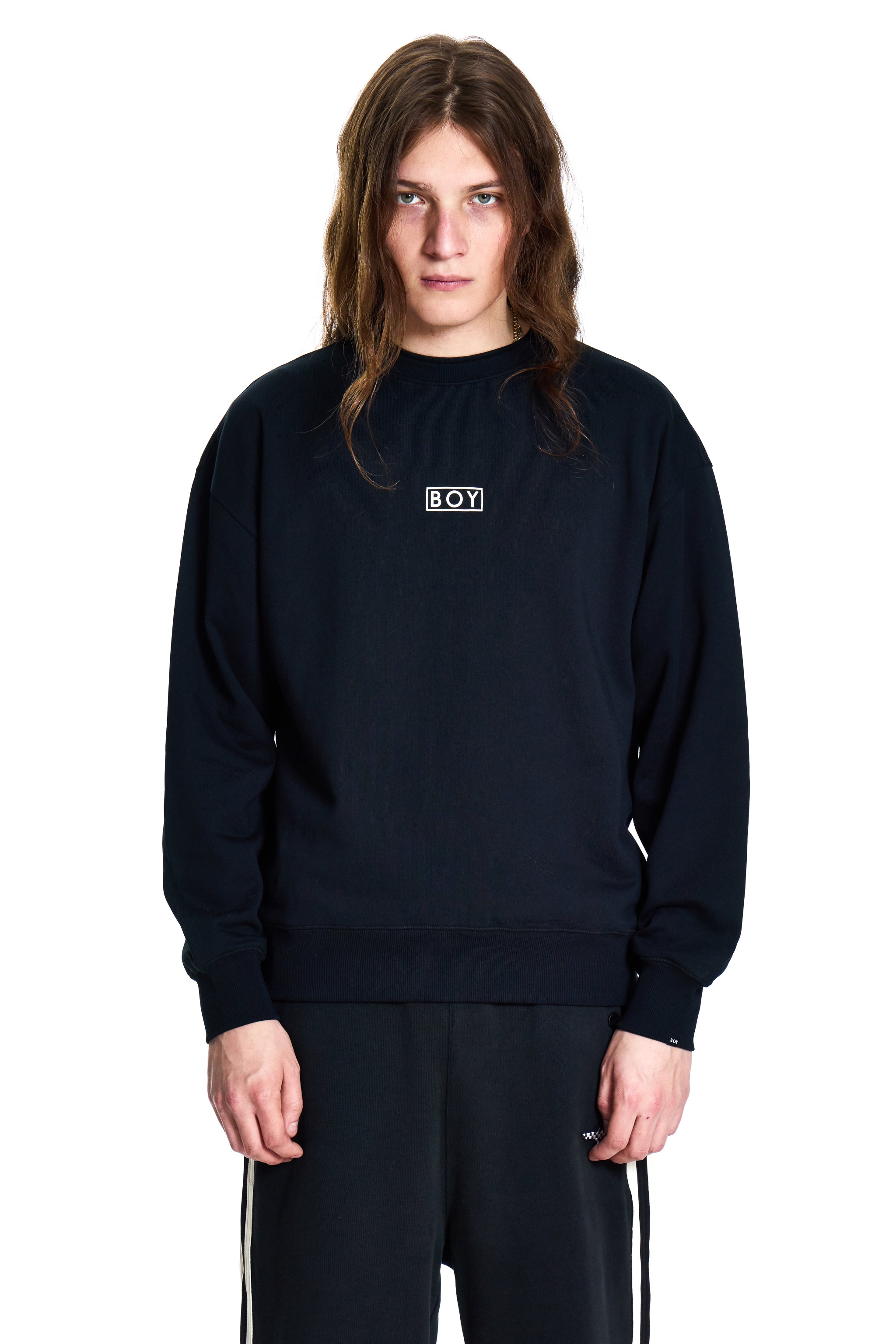 Person wearing a black sweatshirt with a logo on a white background