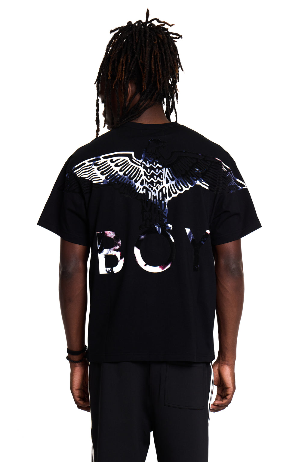 Model wearing a black BOY London t-shirt with a design on the back against a white background