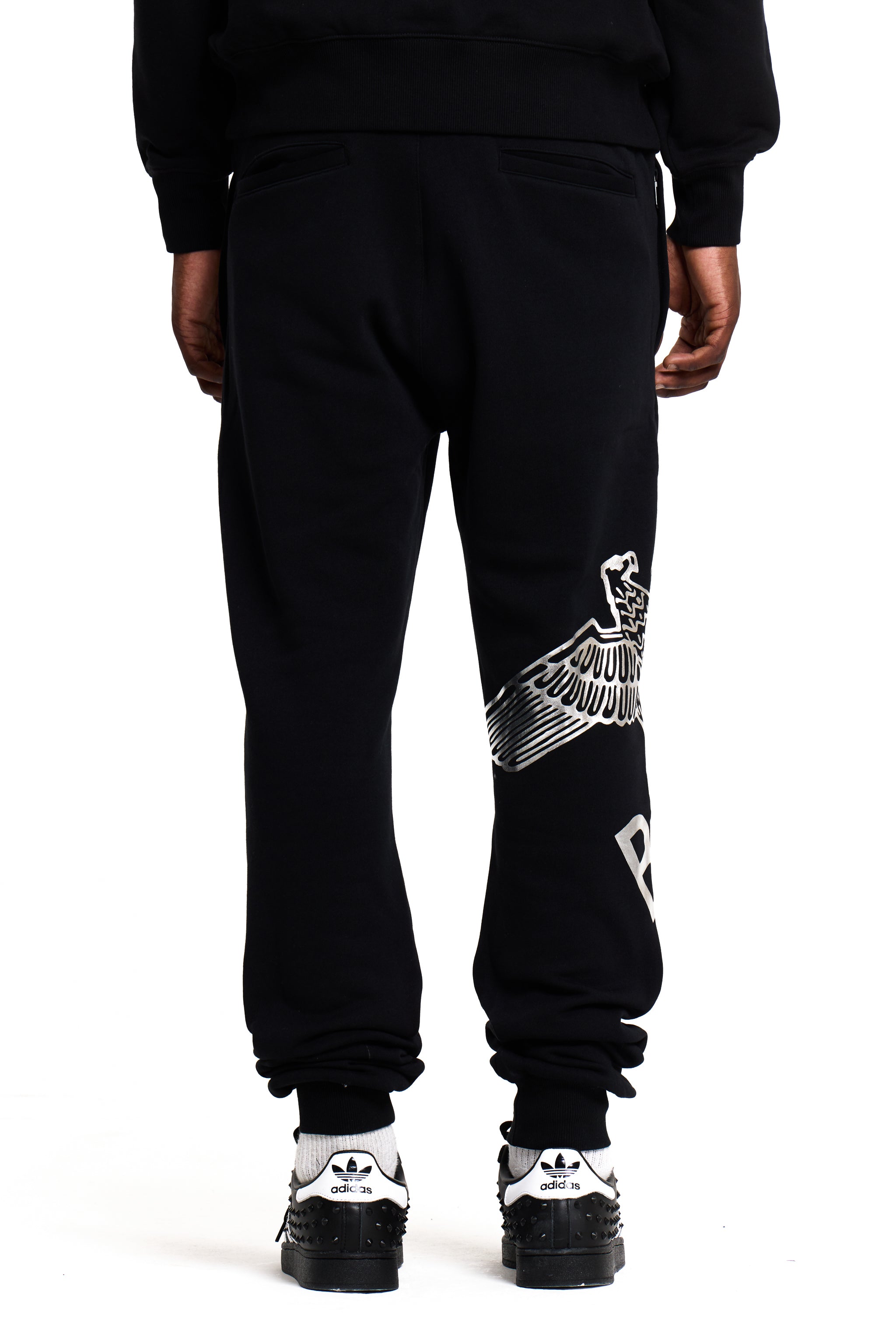 Model wearing Black BOY London sweatpants with white text and graphics on a white background