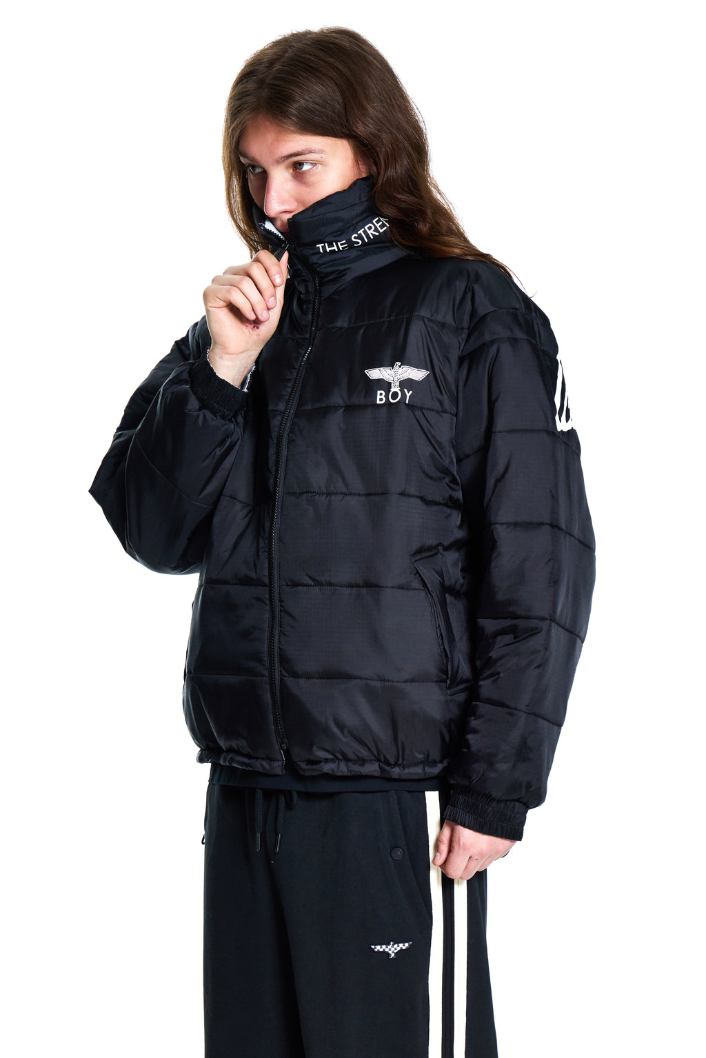 Person wearing a black puffer jacket with branding on a white background