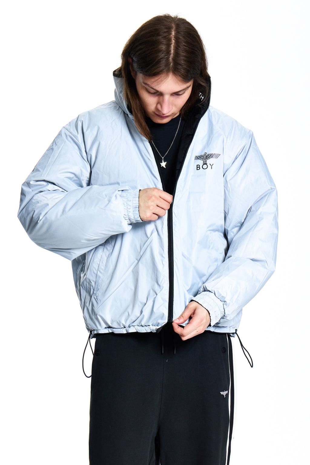 Person wearing a light blue jacket with a brand logo on a white background