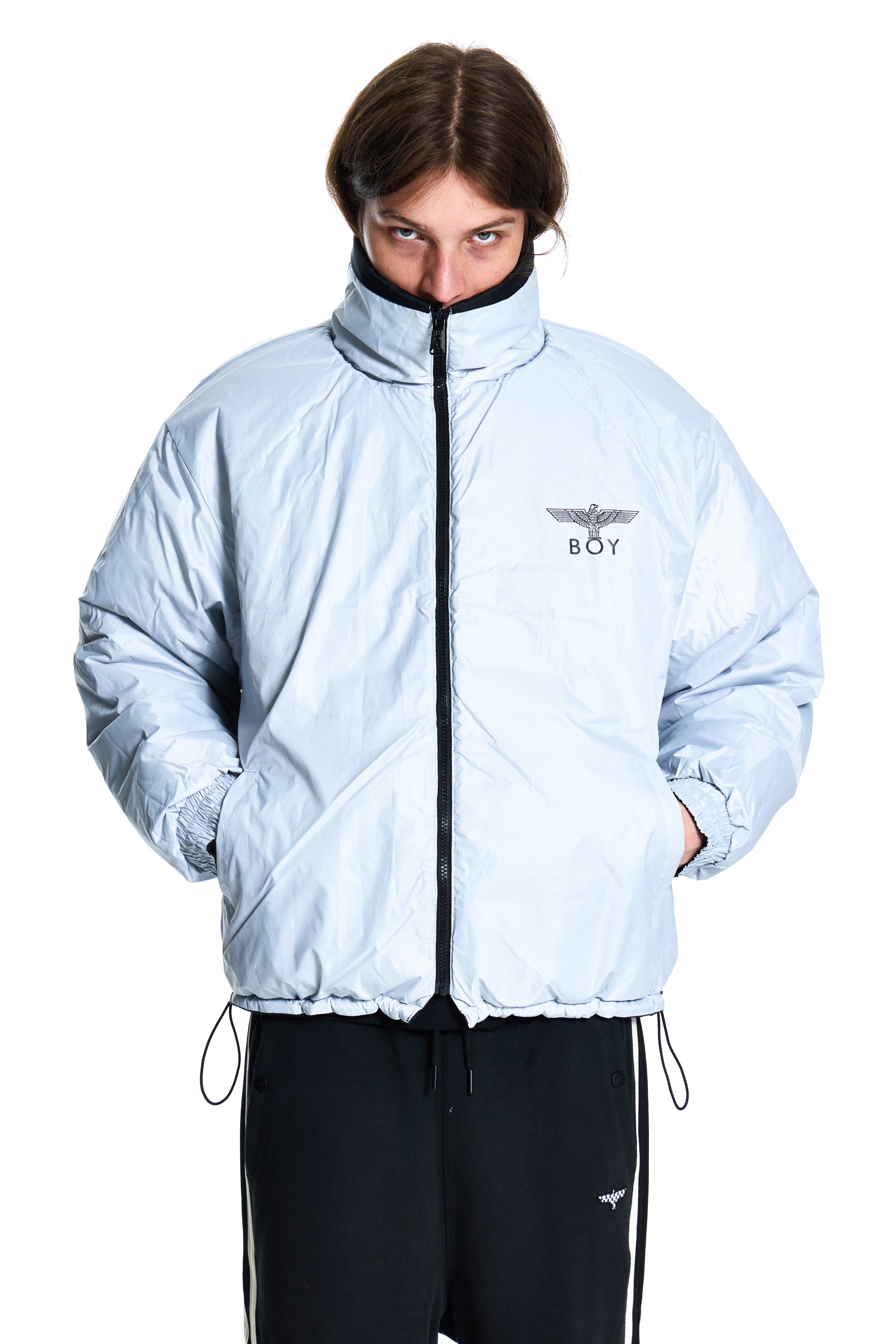 Person wearing a light blue jacket with a brand logo on a white background
