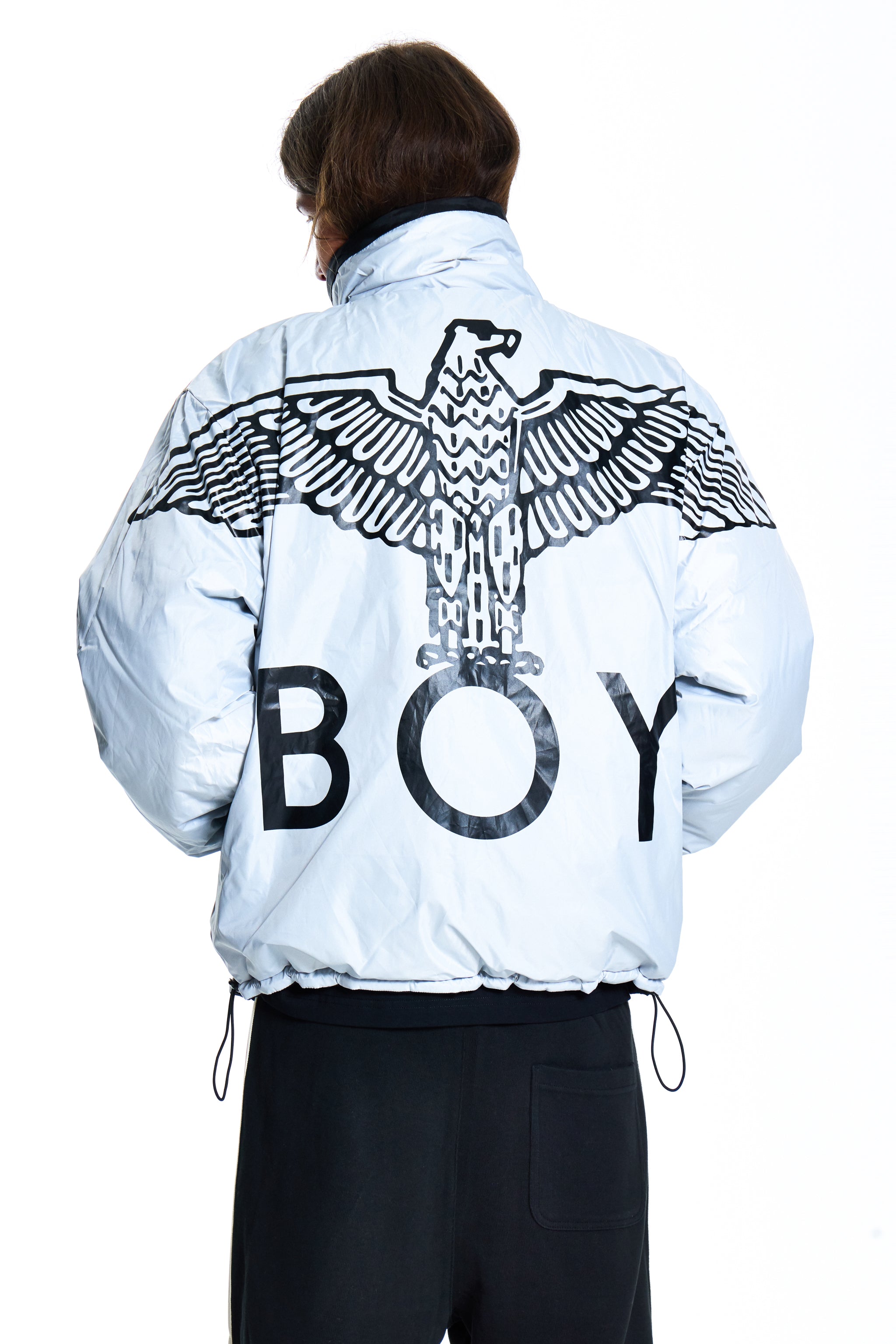 Person wearing a light blue jacket with an eagle design and 'BOY' text on the back, on a white background.