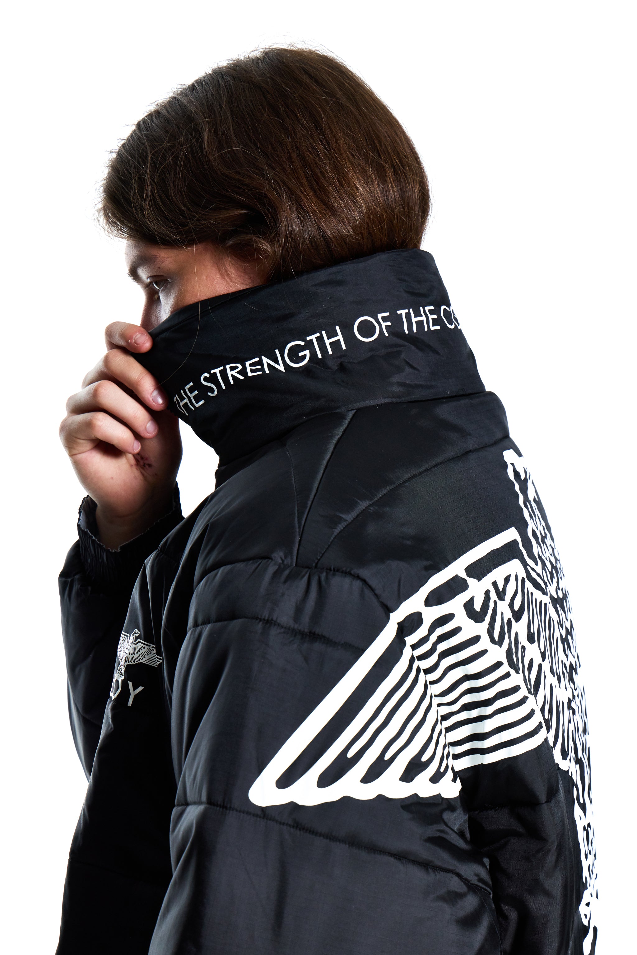 Person wearing a black jacket with white text and designs on a white background