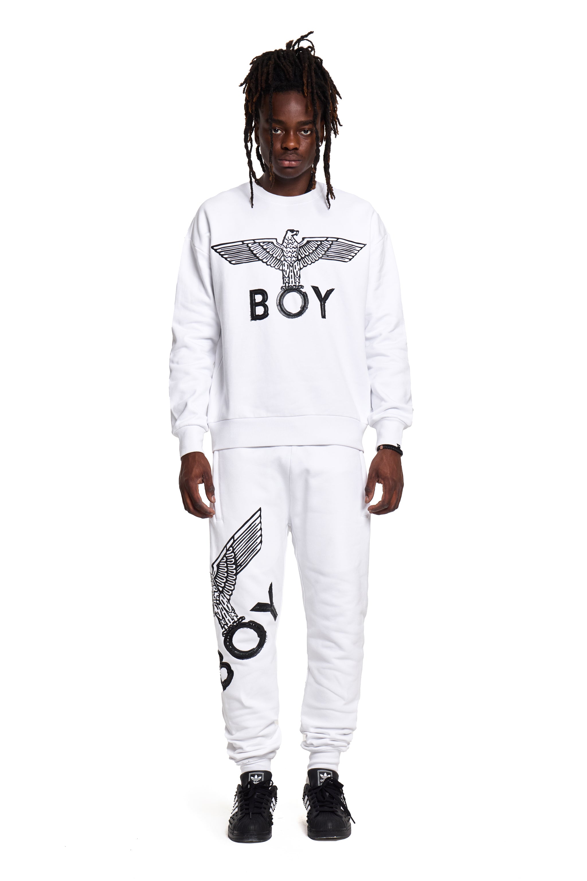 Person wearing a white 'BOY' London branded outfit with black text and logo on a white background