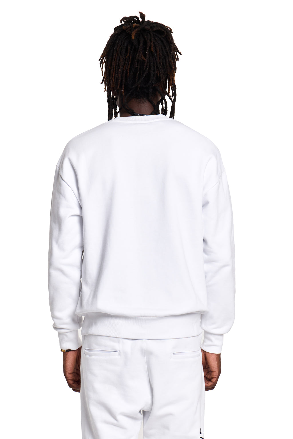 Person wearing a white BOY London sweatshirt and pants on a white background