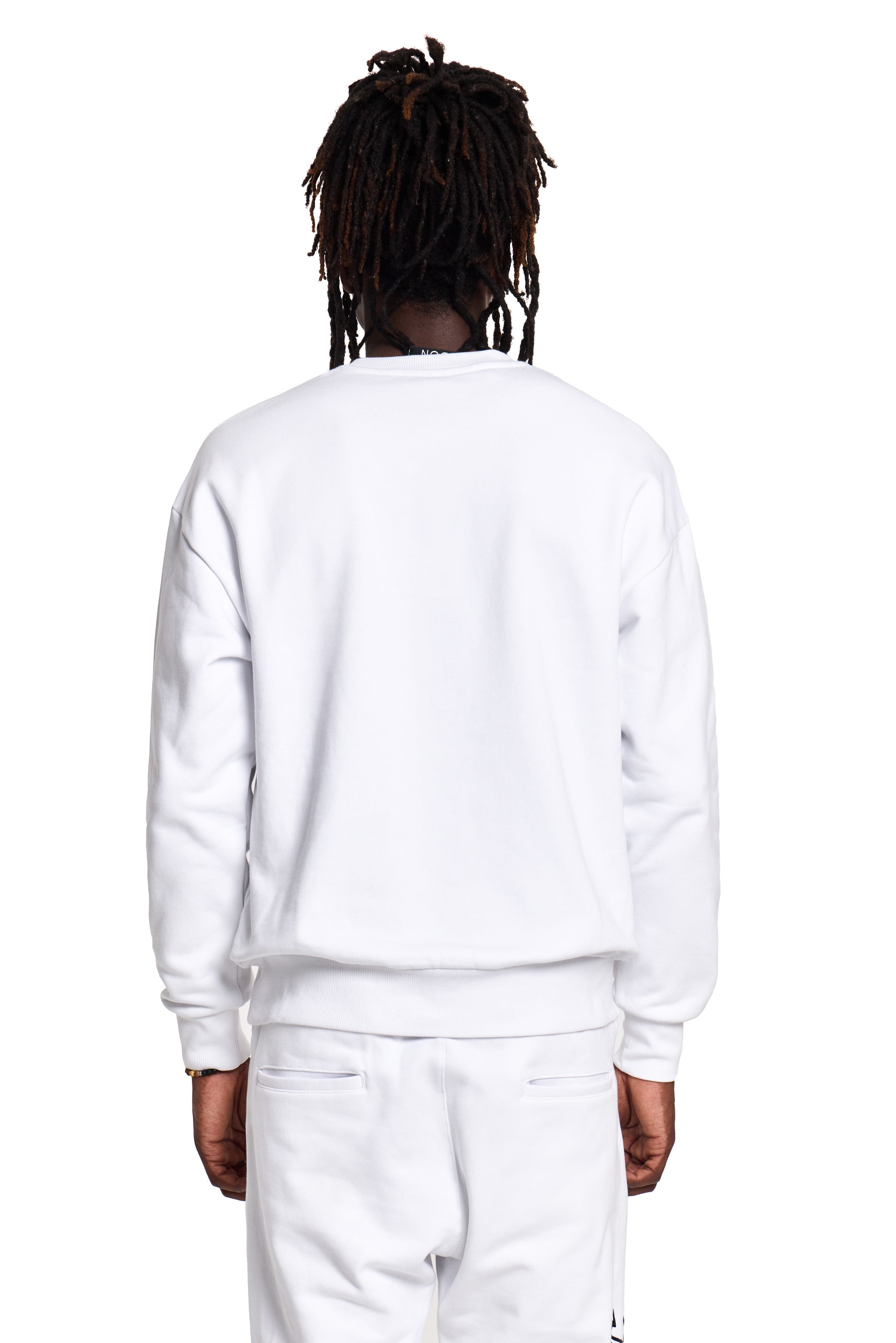 Person wearing a white BOY London sweatshirt and pants on a white background