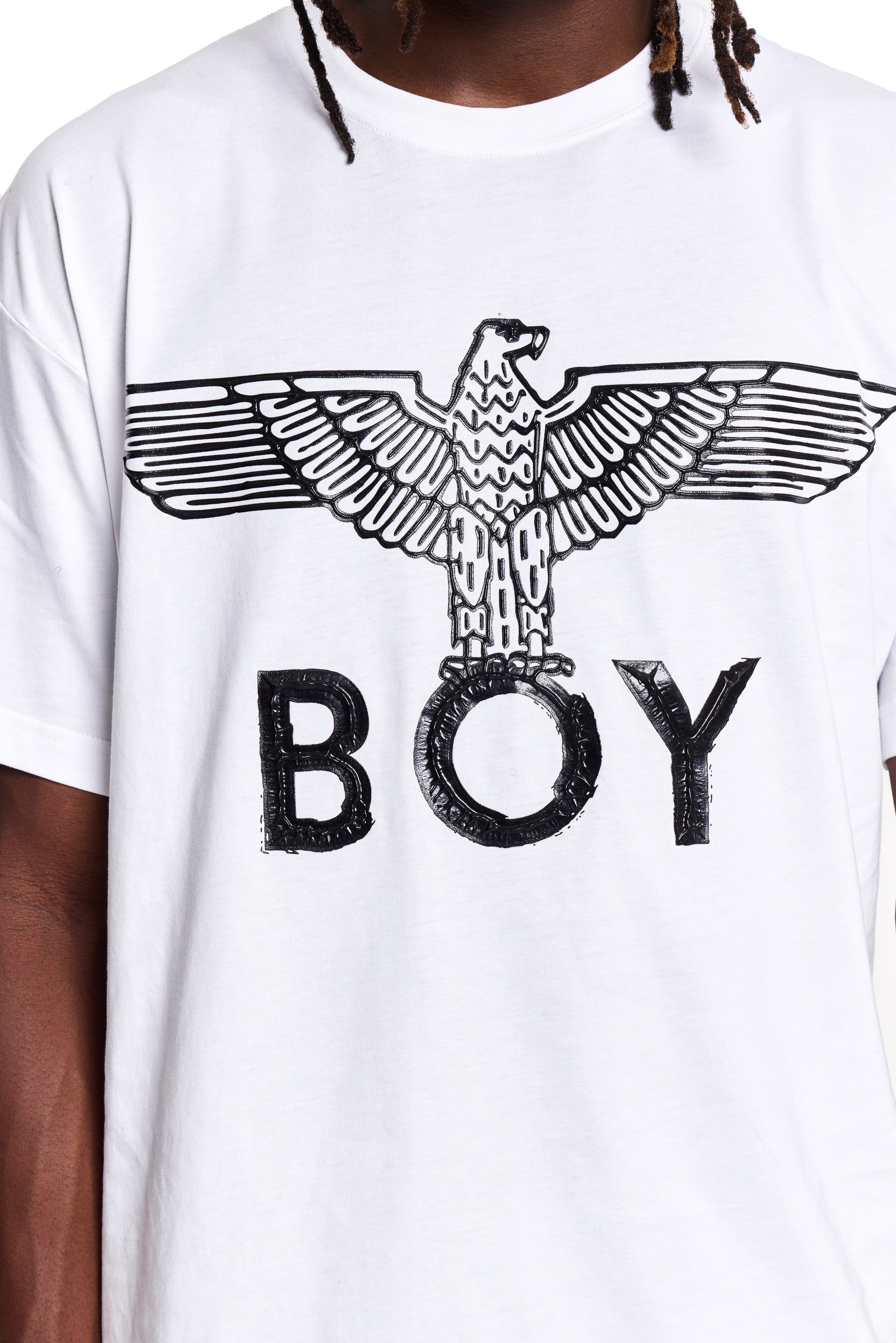 White BOY London t-shirt with black eagle graphic and 'BOY' text on a person wearing it.