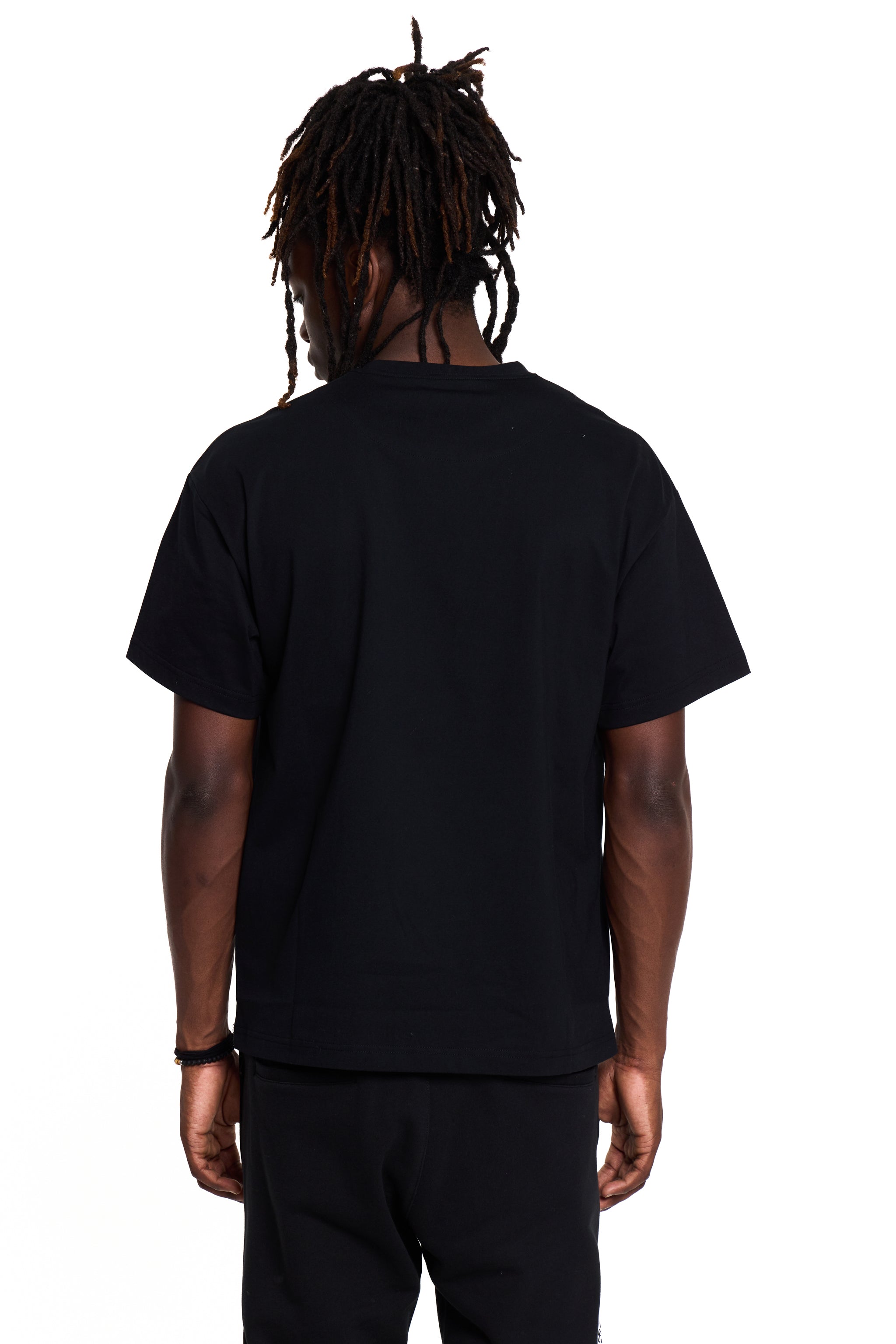 Person wearing a black BOY London t-shirt and pants on a white background