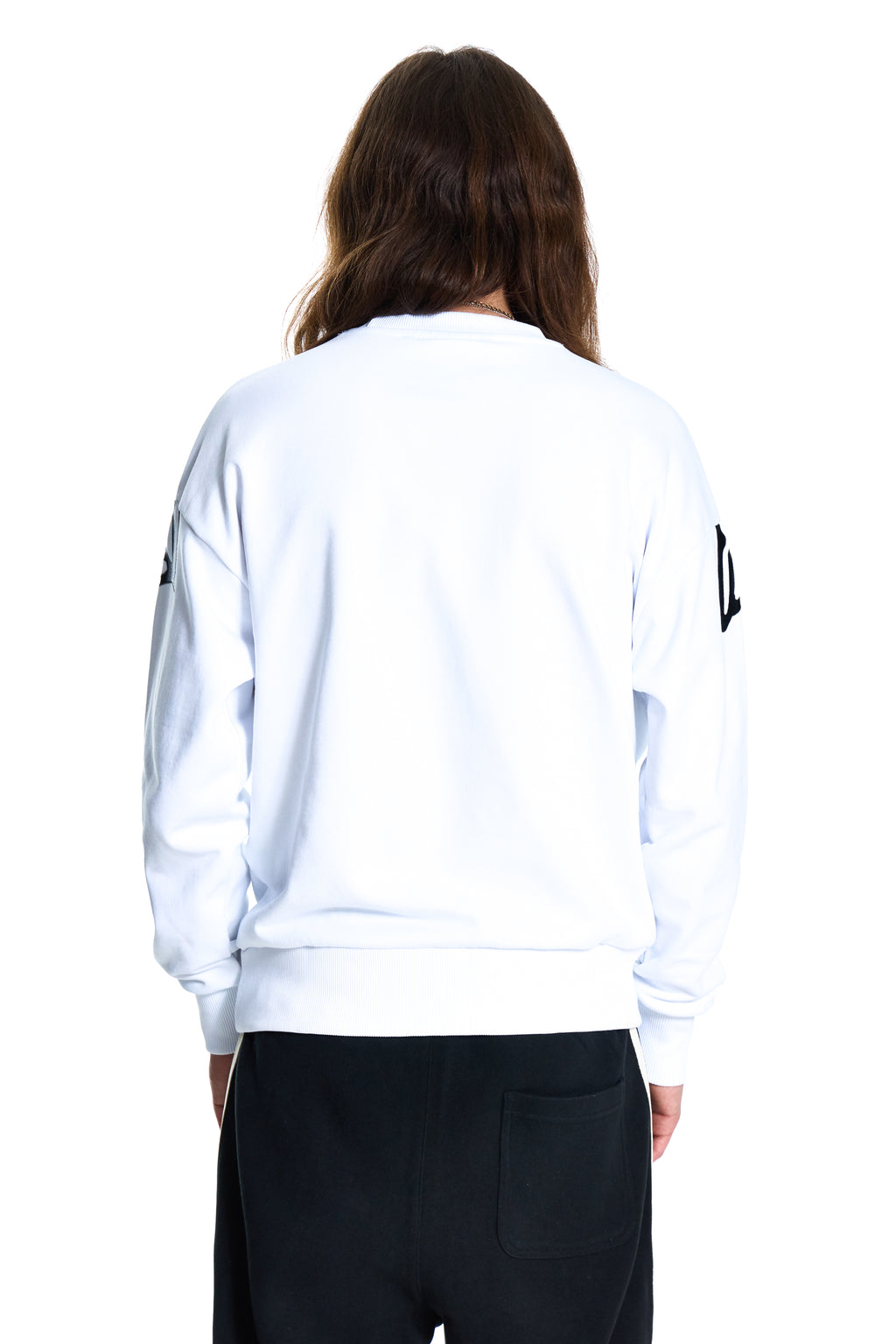 Person wearing a white sweatshirt with black patches on a white background