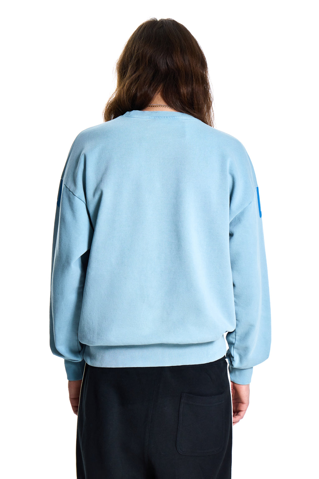 Person wearing a light blue sweater on a white background