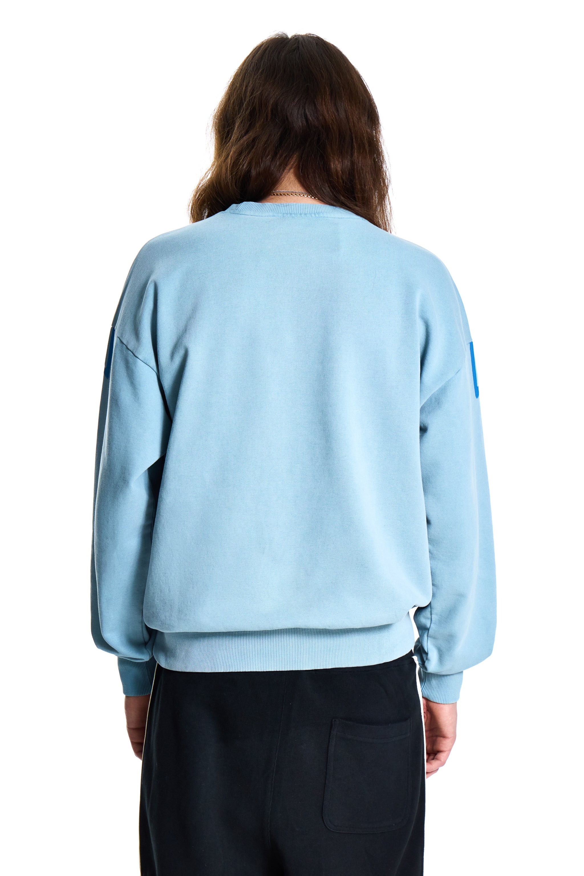Person wearing a light blue sweater on a white background