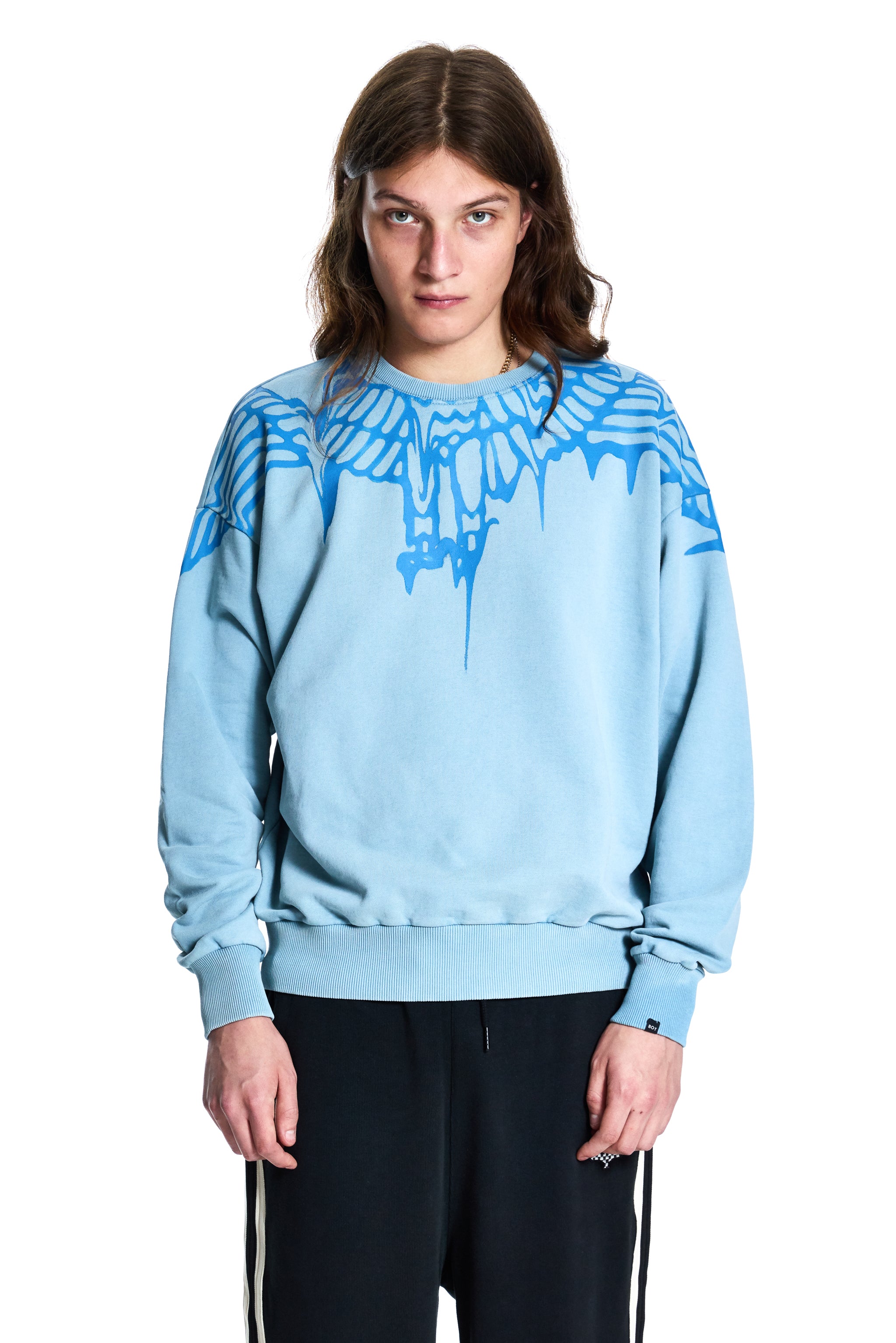 Person wearing a light blue Boy London sweatshirt with a graphic design on a white background