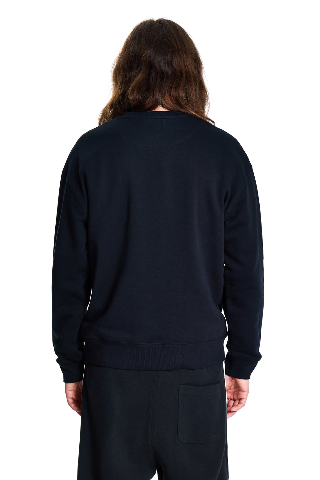 Person wearing a black BOY London sweatshirt and pants on a white background
